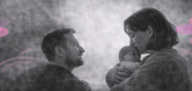 Une mère tenant son nourrisson contre elle, scène en noir et blanc avec accents rose et violet.