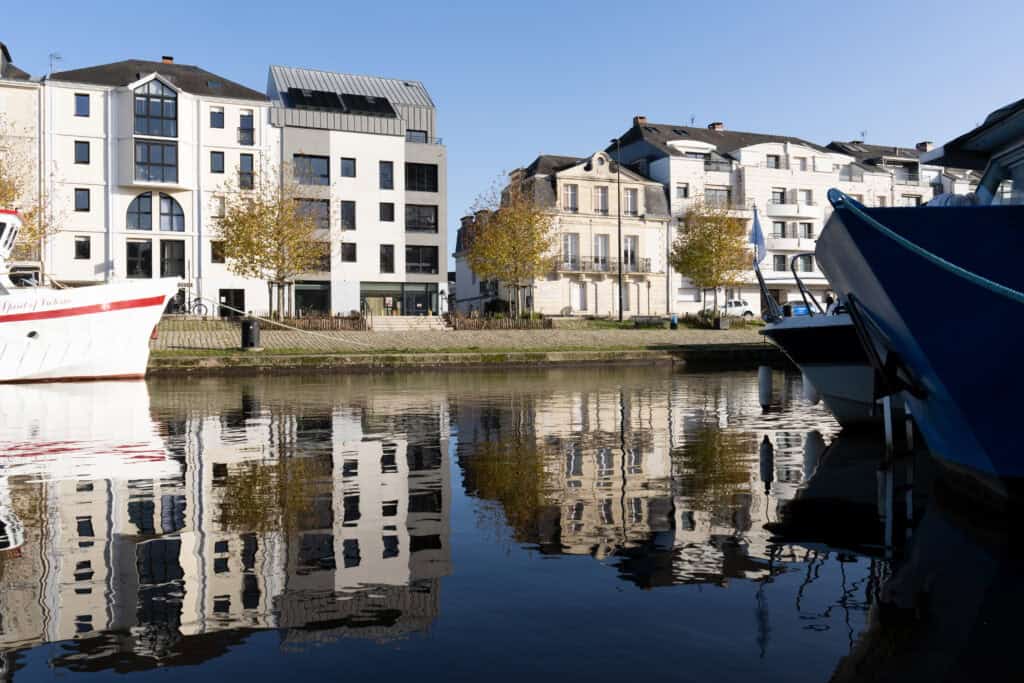 Vue de l’Erdre à Nantes avec bateaux et immeubles se reflétant dans l’eau par temps ensoleillé