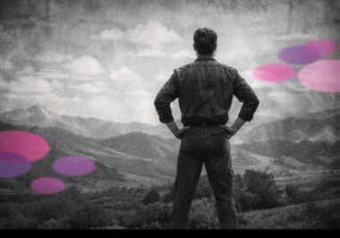 Personne debout en posture de missionnaire, regardant au loin, en noir et blanc, avec des touches rose et violet en arrière-plan.