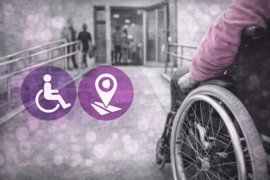 Personne en fauteuil roulant devant un bâtiment accessible avec rampe, illustrant l’accessibilité des locaux de formation Mimethys