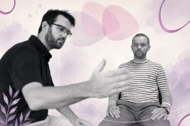 Formateur accompagnant un participant assis lors d’un atelier thérapeutique, illustrant le travail corporel et relationnel en situation clinique.