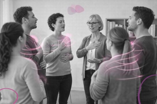 Groupe de professionnels en formation, debout en cercle, travaillant la voix et la présence corporelle dans un cadre thérapeutique.