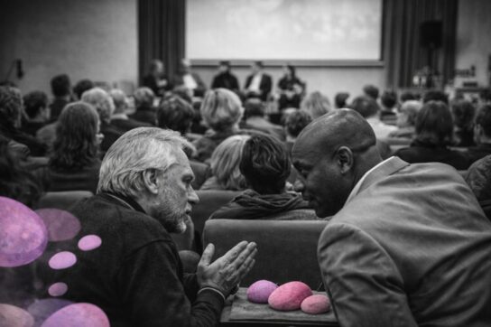 Deux participants en discussion lors du congrès Mimethys 2016, en noir et blanc, avec des galets roses et violets symbolisant le lien relationnel.
