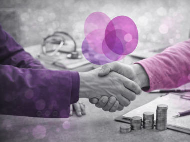 Poignée de main au-dessus d’un bureau avec des piles de pièces, illustrant la prise en charge financière des formations par le FIF PL