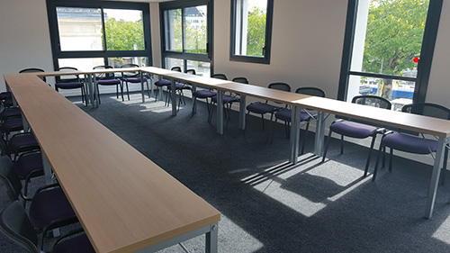 Salle de formation lumineuse à l’Institut Mimethys, aménagée en U avec tables et chaises