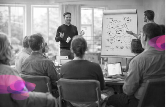 Formateur s’adressant à un groupe de professionnels en formation, dans une salle lumineuse, illustrant l’espace de supervision clinique à l’Institut Mimethys
